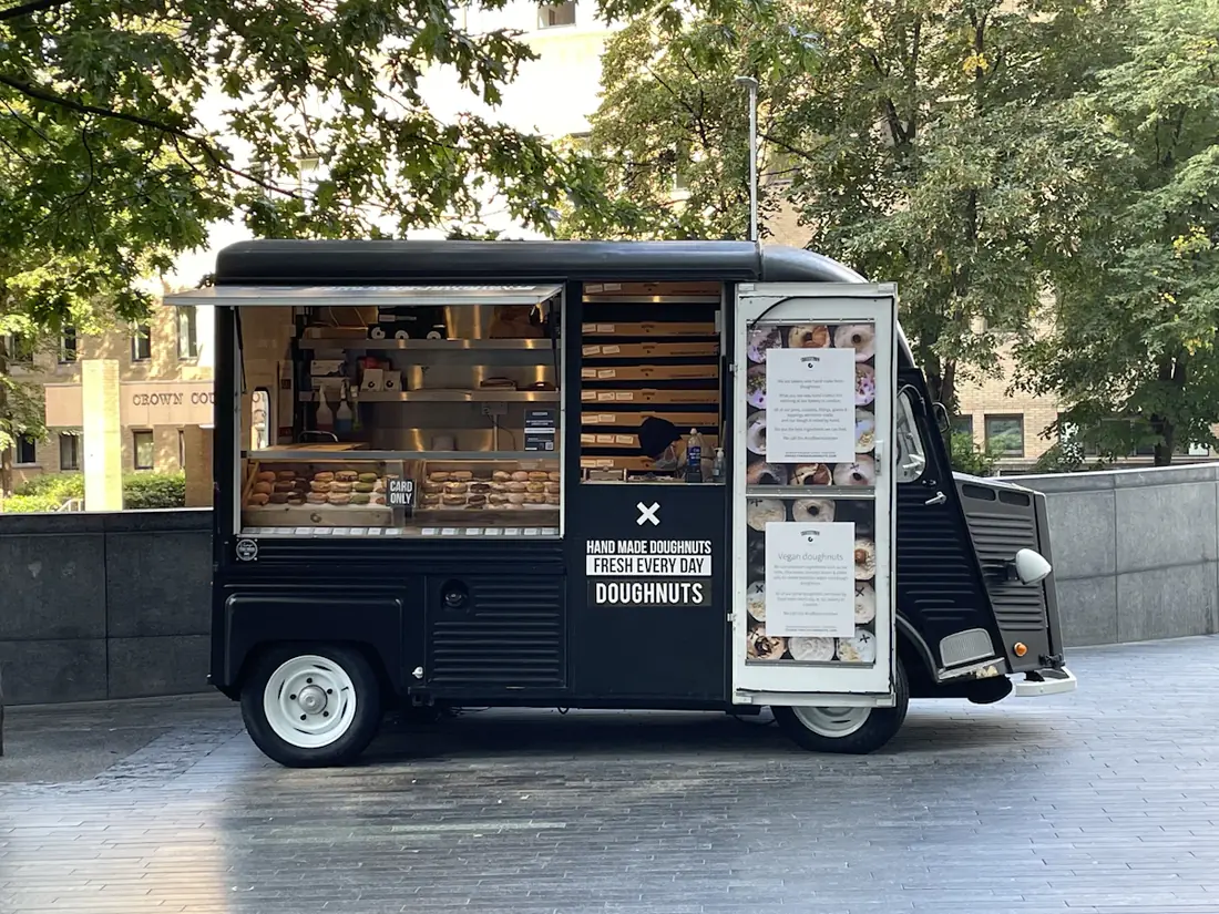 A dark food truck with its service window open